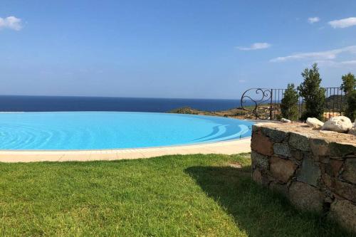 una gran piscina azul junto a una pared de piedra en The refuge on the sea..., en Tertenìa