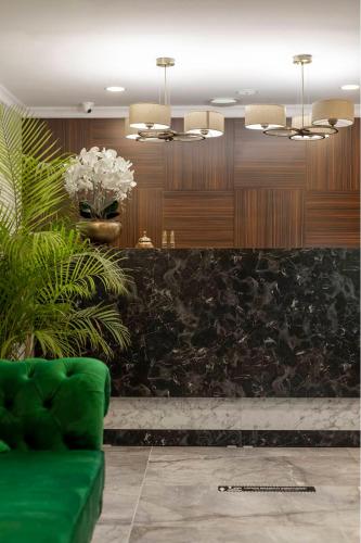 a lobby with a green couch and a vase of flowers at LAGUN CASTLE HOTEL&SPA in Yalova