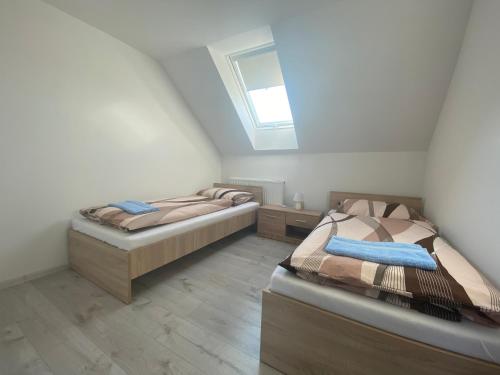 two twin beds in a room with a skylight at Penzión u Komu in Žaškov