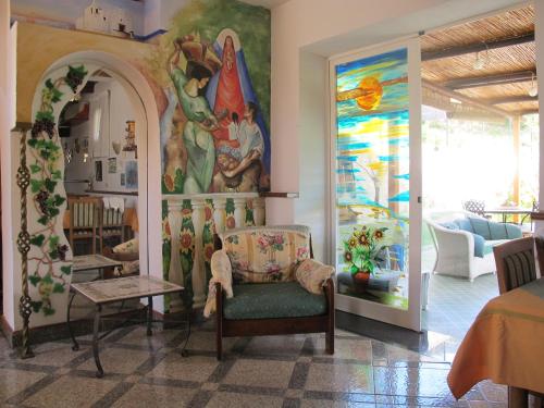 a room with a chair and a painting on the wall at Aparthotel Villa Marinù in Ischia