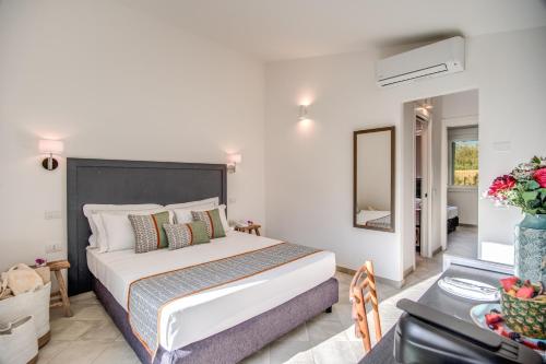 a bedroom with a bed and a table and a mirror at Cala Sinzias Resort in Castiadas