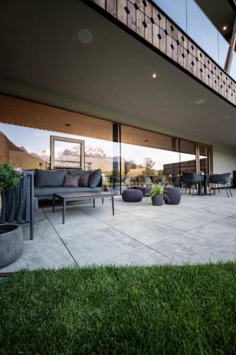 a patio with a couch and tables and windows at Aparthotel Gamz in Sesto