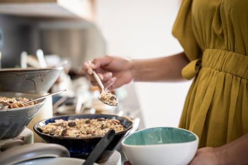 a person stirring a bowl of food with a spoon at Aparthotel Gamz in Sesto