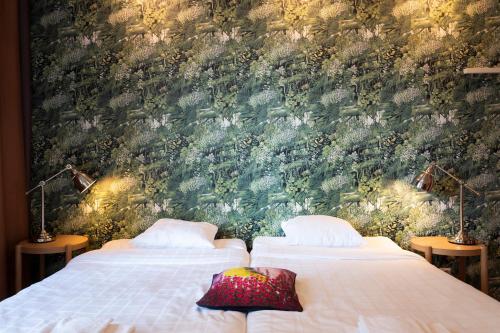 2 Betten in einem Schlafzimmer mit Wandbild in der Unterkunft Hotel Finn in Helsinki