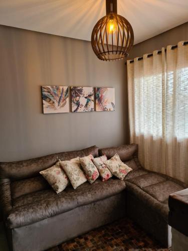 a couch in a living room with pillows on it at Refúgio dos Coiotes in Cambara do Sul