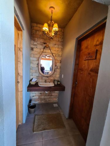 a bathroom with a sink and a mirror and a chandelier at Refúgio dos Coiotes in Cambara do Sul