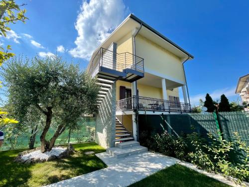una casa con escaleras y un árbol en el patio en Villa Elena, en Desenzano del Garda