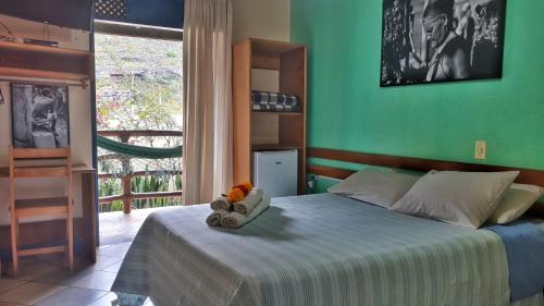 1 dormitorio con 1 cama con pared verde en Pousada Recanto da Chapada en Mucugê