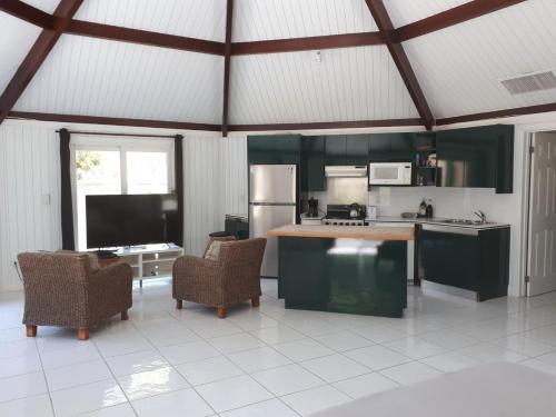 a kitchen with green cabinets and chairs in a room at Private and Peaceful Cottage at the Beach in Nassau