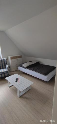 a white room with a bed and a white table at De hümmelske Bur in Friesoythe