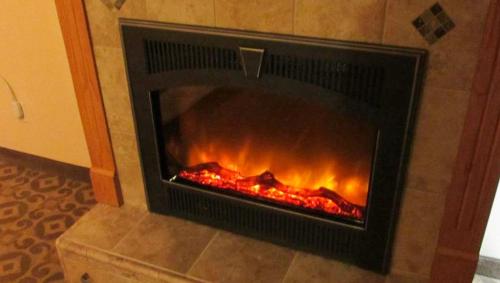 a large fireplace with a fire in it at Magnuson Grand Pioneer Inn and Suites in Escanaba