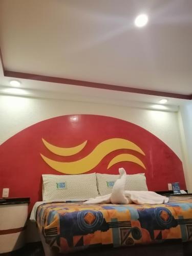 a bed with a red and yellow sign on the wall at Hotel Atlántico in Mexico City