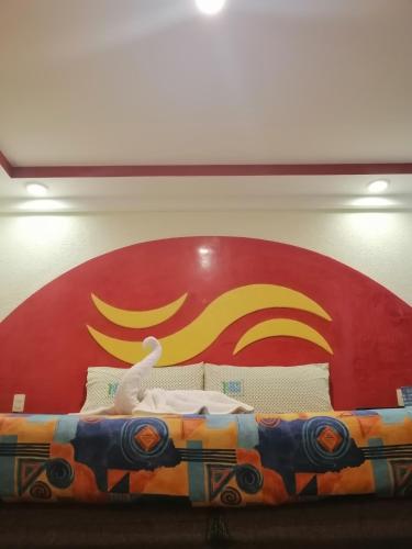 a bed with a red and yellow sign behind it at Hotel Atlántico in Mexico City