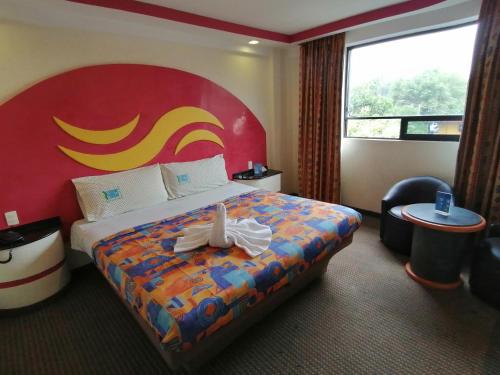 メキシコシティにあるHotel Atlánticoのホテルルーム ベッド1台(赤いヘッドボード付)