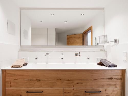 een badkamer met een wastafel en een grote spiegel bij Zum Gassenschmied in Schwangau