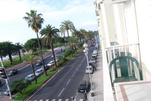 a view from a balcony of a street with palm trees at Hôtel Azur in Nice