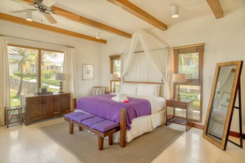 - une chambre avec un lit doté de draps violets et une fenêtre dans l'établissement Las Verandas Hotel & Villas, à First Bight