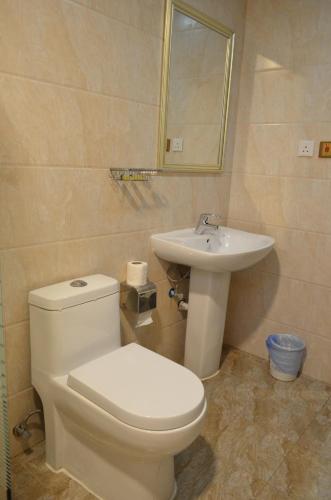 a bathroom with a toilet and a sink at Open Hotel Alolaya in Al Khobar