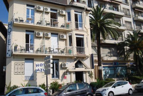 a building with cars parked in front of it at Hôtel Azur in Nice