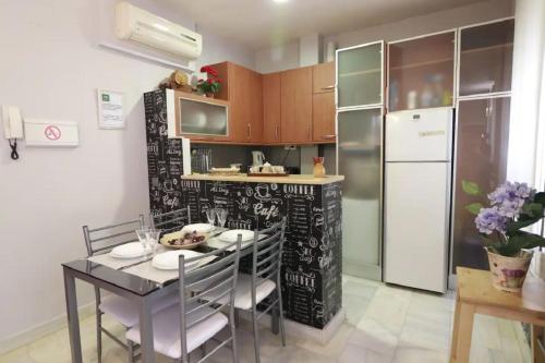 uma cozinha com uma mesa de jantar e um frigorífico em Apartamento Cristo de Burgos - Kainga Homes em Sevilha