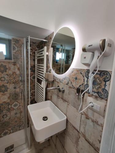a bathroom with a sink and a mirror at RomAntica in Polignano a Mare