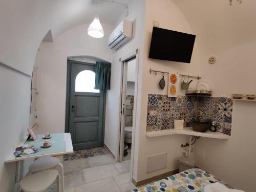 a room with a door and a bed and a tv at RomAntica in Polignano a Mare