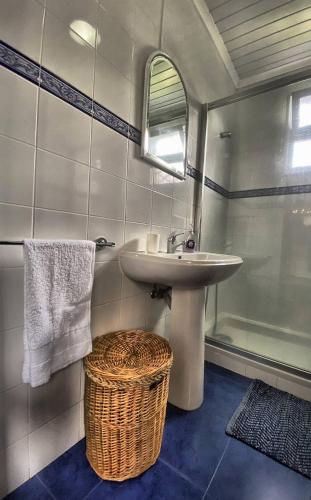 a bathroom with a sink and a mirror and a shower at Casa na Ribeira in Ribeira Grande