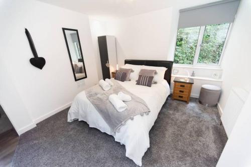 a bedroom with a large white bed with towels on it at Modern House in Looe, Near Beach and Bars with Great Views and free access to a nearby Indoor Swimming Pool in Looe
