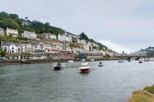 a group of boats in a river with houses at Modern House in Looe, Near Beach and Bars with Great Views and free access to a nearby Indoor Swimming Pool in Looe