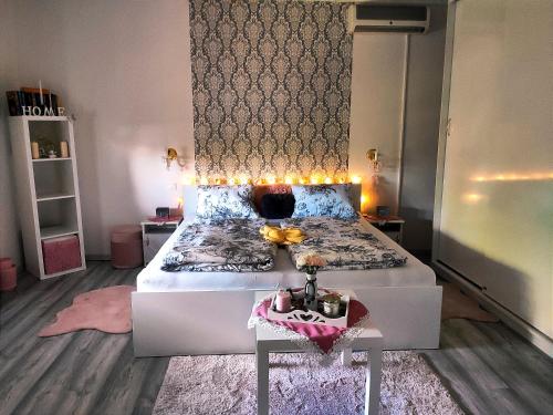 a bedroom with a large bed with lights on it at Szandra Vendégház in Öskü
