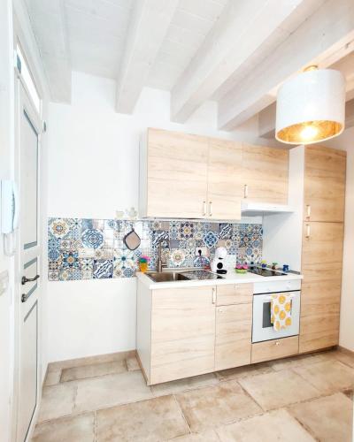 a kitchen with wooden cabinets and a sink at RomAntica in Polignano a Mare