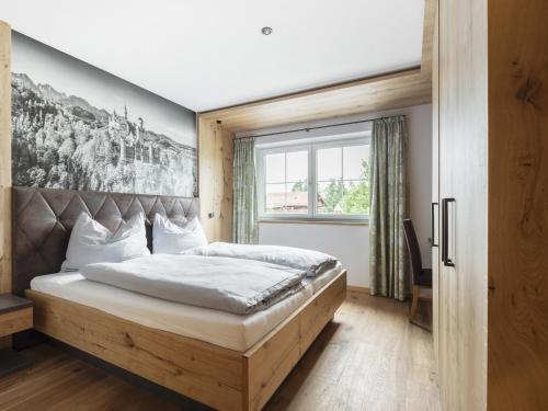 een slaapkamer met een bed en een groot raam bij Zum Gassenschmied in Schwangau