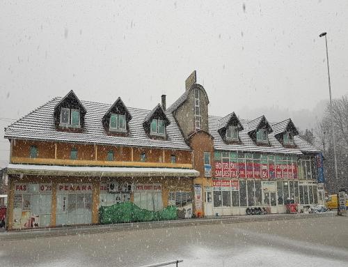 ein Gebäude mit einem schneebedeckten Dach auf einer Straße in der Unterkunft Guesthouse Meče in Bijelo Polje