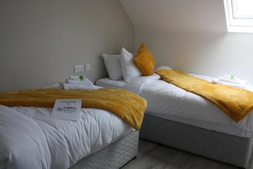 a bed with a white comforter and pillows on it at The Leitrim Inn and Blueway Lodge in Leitrim