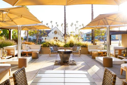 a patio with tables and chairs and umbrellas at Ambrose Hotel in Los Angeles