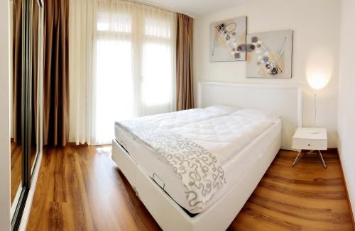 1 dormitorio con 1 cama blanca grande y suelo de madera en Luxury Apartments by Livingdowntown, en Zúrich