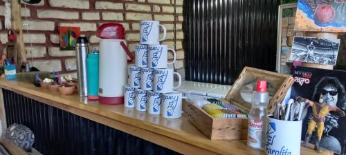a kitchen counter filled with bottles, cups, and other items at El Farolito Hostel in Tilcara