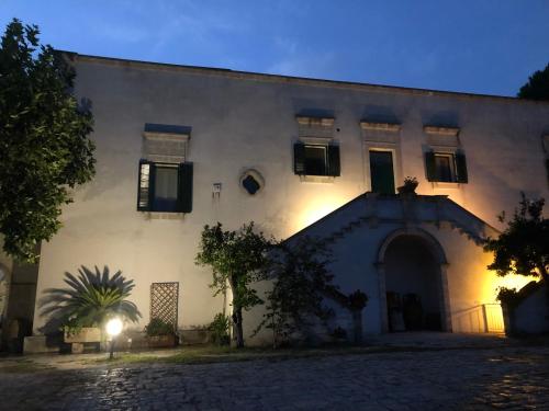 a large white building with a tree in front of it at MASSERIA INCANTAMENTO Suite Bouganville in Latiano
