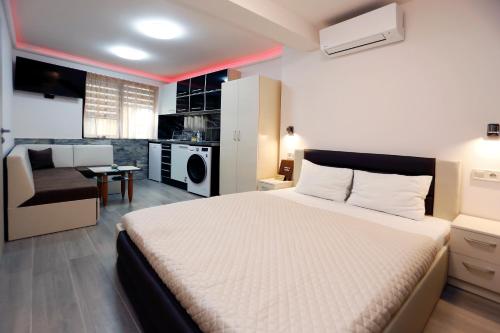 a bedroom with a large bed and a kitchen at Deluxe 2 Studios City Center in Burgas City
