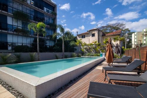 a swimming pool with two lounge chairs next to a building at 360 Vila Madalena in Sao Paulo