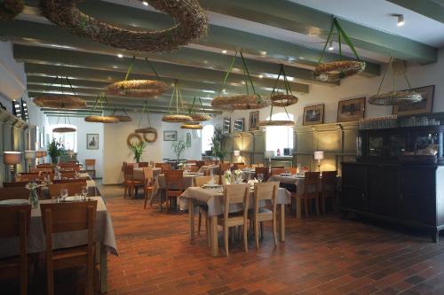 a dining room with tables and chairs and chandeliers at Spichlerz na Krakowskiej in Kazimierz Dolny