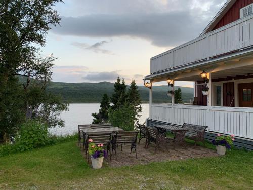 a porch of a house with a table and benches at Strandgården Fjällnäs in Tänndalen