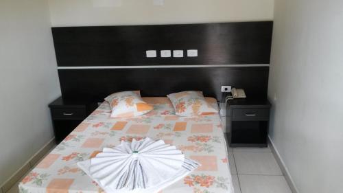 a bedroom with a bed with an umbrella on it at Hotel Joabi in São José dos Campos