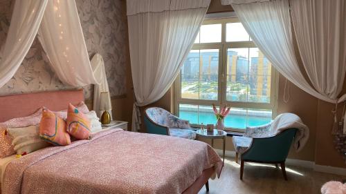 ein Schlafzimmer mit einem Bett und einem großen Fenster in der Unterkunft B-LBAIT KAEC Honeymoon Style for family in King Abdullah Economic City