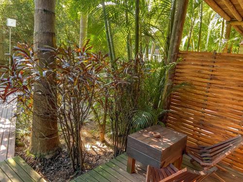 a wooden bench with a wooden box sitting on a deck at Morada da Praia do Rosa Pousada in Praia do Rosa