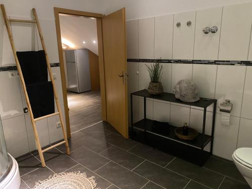a bathroom with a toilet and a door to a room at Im Herzen Bayerns in Töging am Inn
