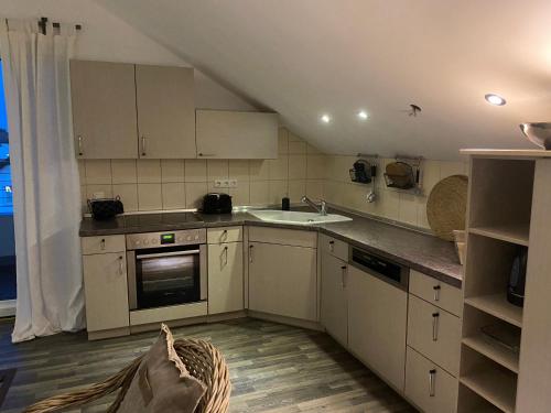 a kitchen with white cabinets and a sink at Im Herzen Bayerns in Töging am Inn