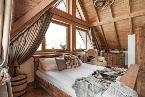 a bedroom with a large bed in a wooden ceiling at Nosalowski Wypas in Zakopane