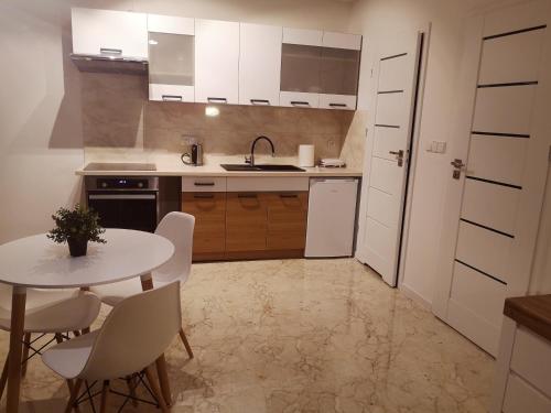 een keuken met een tafel en stoelen en een wastafel bij Apartament Źródełko in Bochnia