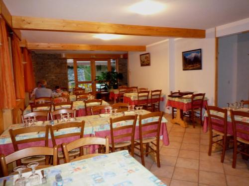 un restaurant avec des tables et des chaises avec des gens assis dessus dans l'établissement Chez Passoud, à Vaujany